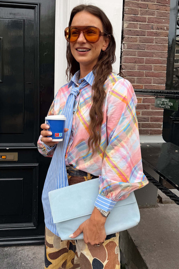 Pastel check shirt with a blue striped pussy bow and cuffed sleeves, styled in a London street style look.