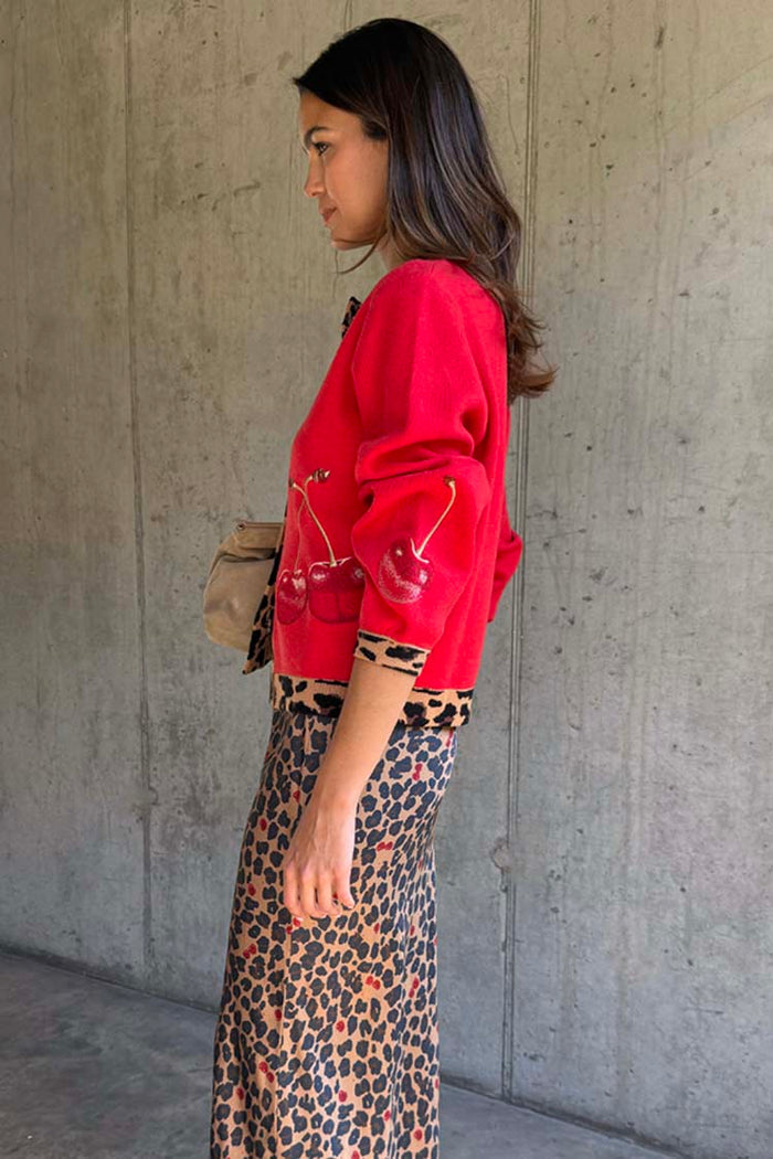 Red Cherry Holly Cardigan with embellished cherry motifs and leopard print trim, paired with a leopard skirt.