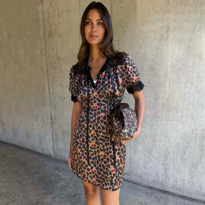Cherry Leopard Mini Lyla Dress with black lace trims, tie neck and puff sleeves, styled with a coordinating clutch bag.