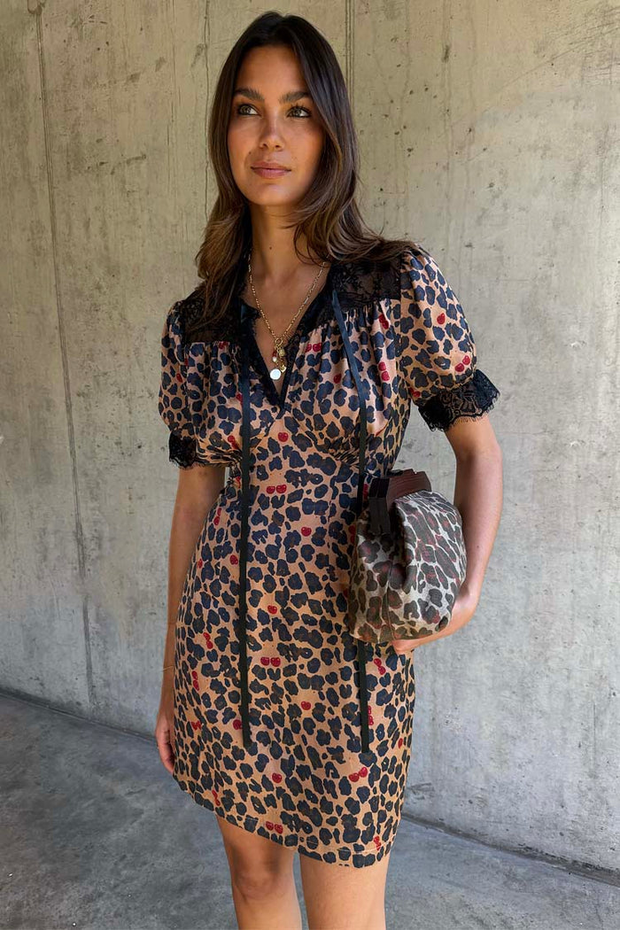 Cherry Leopard Mini Lyla Dress featuring black lace trims, ribbon ties, and cherry leopard print, designed in London.