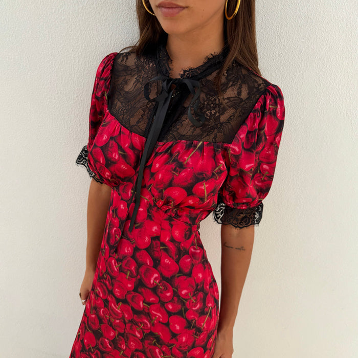 Cherry Lyla Dress in red featuring an all-over cherry print, black lace detailing and a grosgrain neck tie.