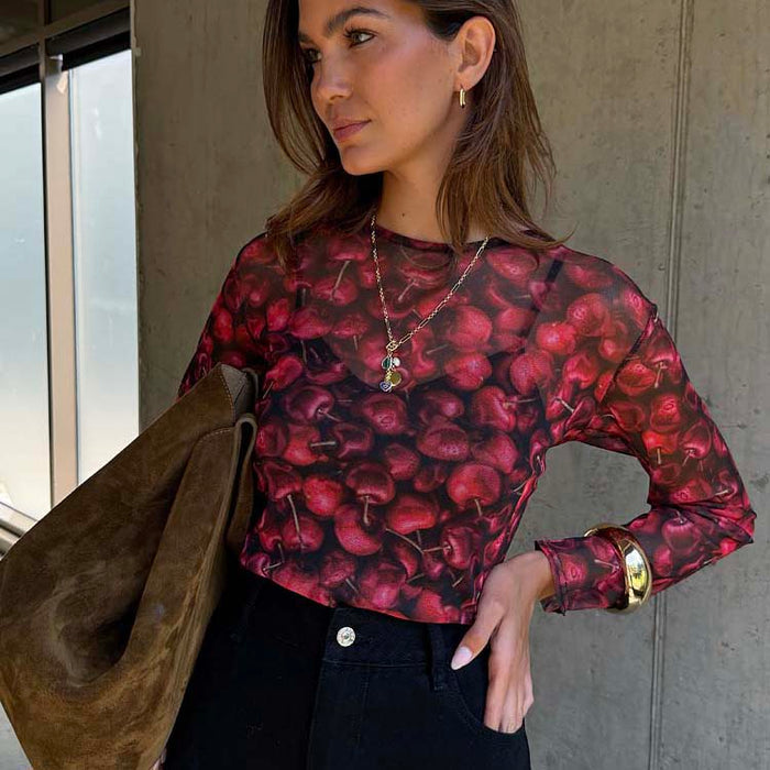 Sheer Cherry Mesh Long Sleeve Top with a red cherry print, styled with black trousers and gold jewellery.