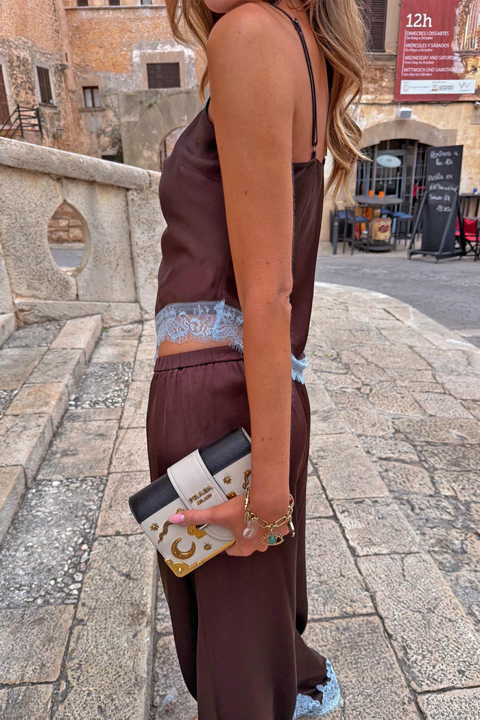Chocolate Aurelia Top with light blue lace trim and matching trousers, shown in an outdoor street setting.