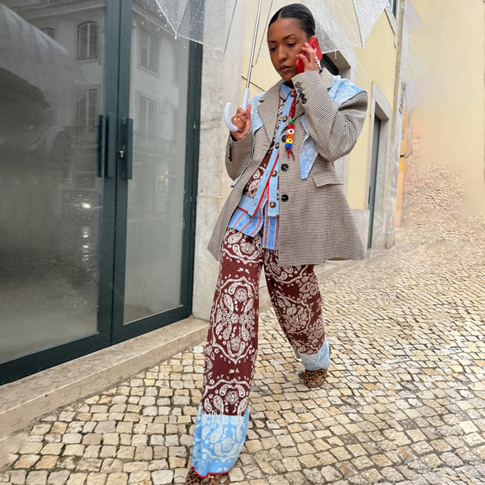 Chocolate Bandana Wide Leg Trousers with a blue contrast hem, styled with a blazer and umbrella for a London look.