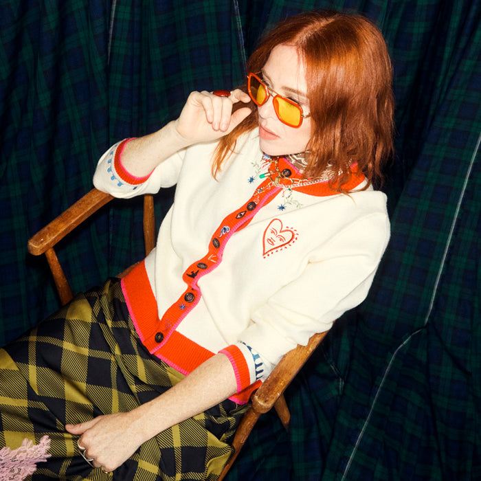 White Choose Love Cardigan with orange trim and heart embroidery, worn by Angela Scanlon for our charity collaboration.