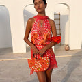 Coral Fawn Poppy Lily Top featuring deer and poppy prints with a tie neck, styled with a matching beaded bag.