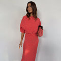 Coral Plisse Tilly Dress with gold flecks, textured fabric and wide sleeves, styled with a pink beaded bag.