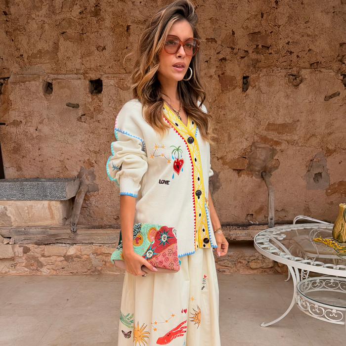 Cream Celestial Martha Cardigan in a soft-touch knit with embroidered motifs and a yellow hem, styled with a matching skirt.