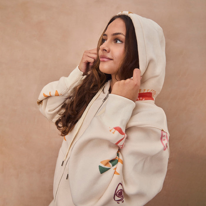 Cream Sundazed Accessible Hoodie with colourful abstract prints on the sleeves and hood, shown on a model.