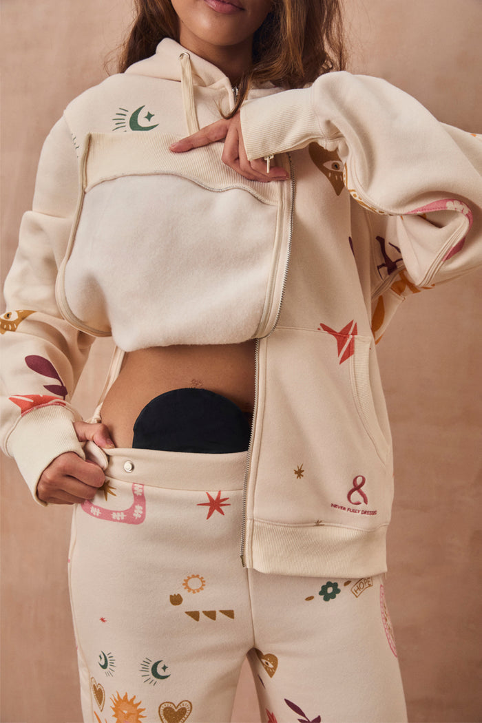 Cream Sundazed Accessible Hoodie with unique symbols, featuring concealed zips for easy medical treatment access.