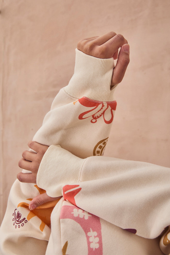 Cream Sundazed Accessible Hoodie by NFD x Porto & Bello with a sun print and thumb holes, designed in London.