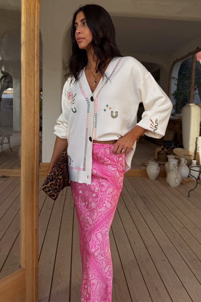 Cream Western Martha Cardigan with embroidered western motifs and cross-stitching, paired with a pink paisley skirt.