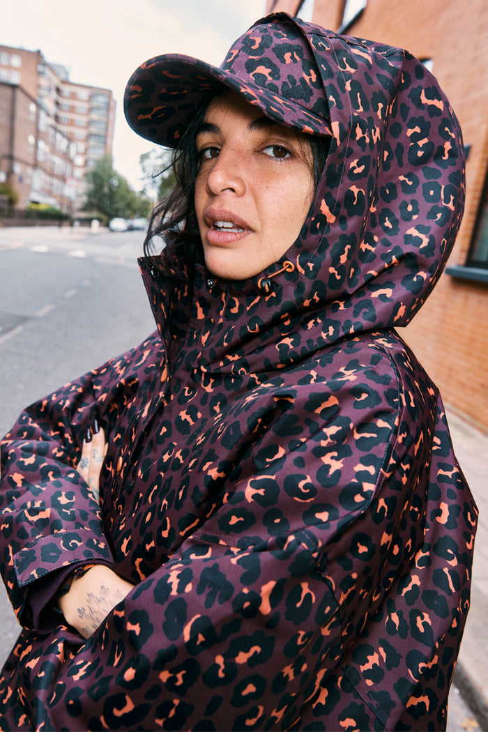 Dark Leopard Cap in iconic burgundy leopard print, styled with a matching hooded jacket for a casual London look.