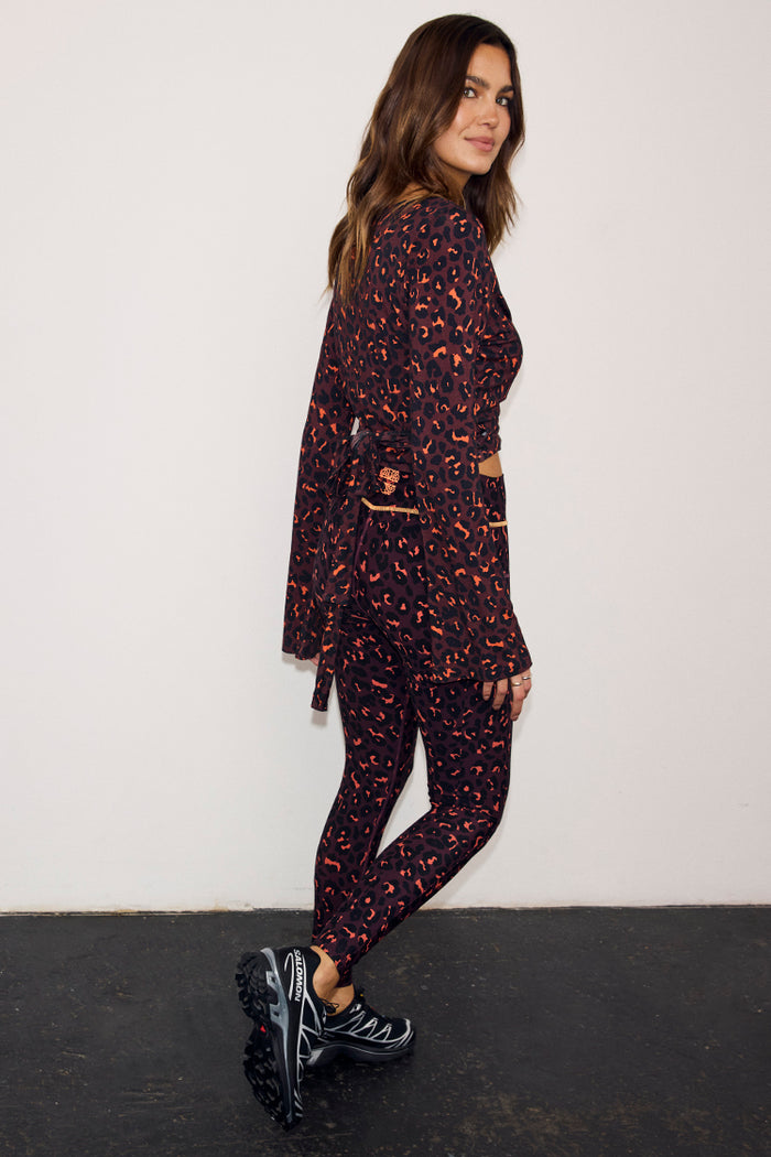 Dark Leopard Leggings with orange detailing and a matching leopard print wrap top with wide sleeves.