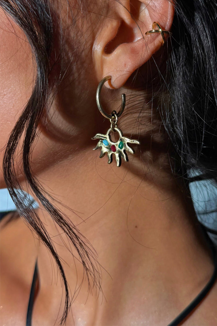 Deloris Sun Hoop Earring with gold-tone sun motif and semi-precious stones, styled on a model’s ear.