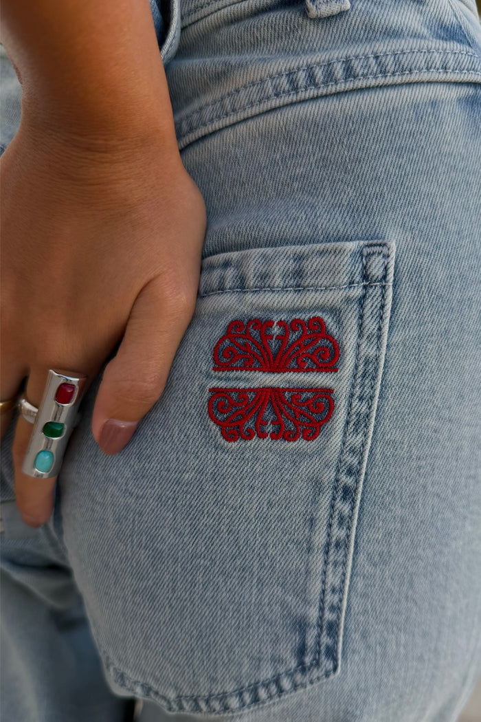 Deloris Whistle Ring with colourful gemstones and a chunky silver finish, styled with embroidered denim jeans.