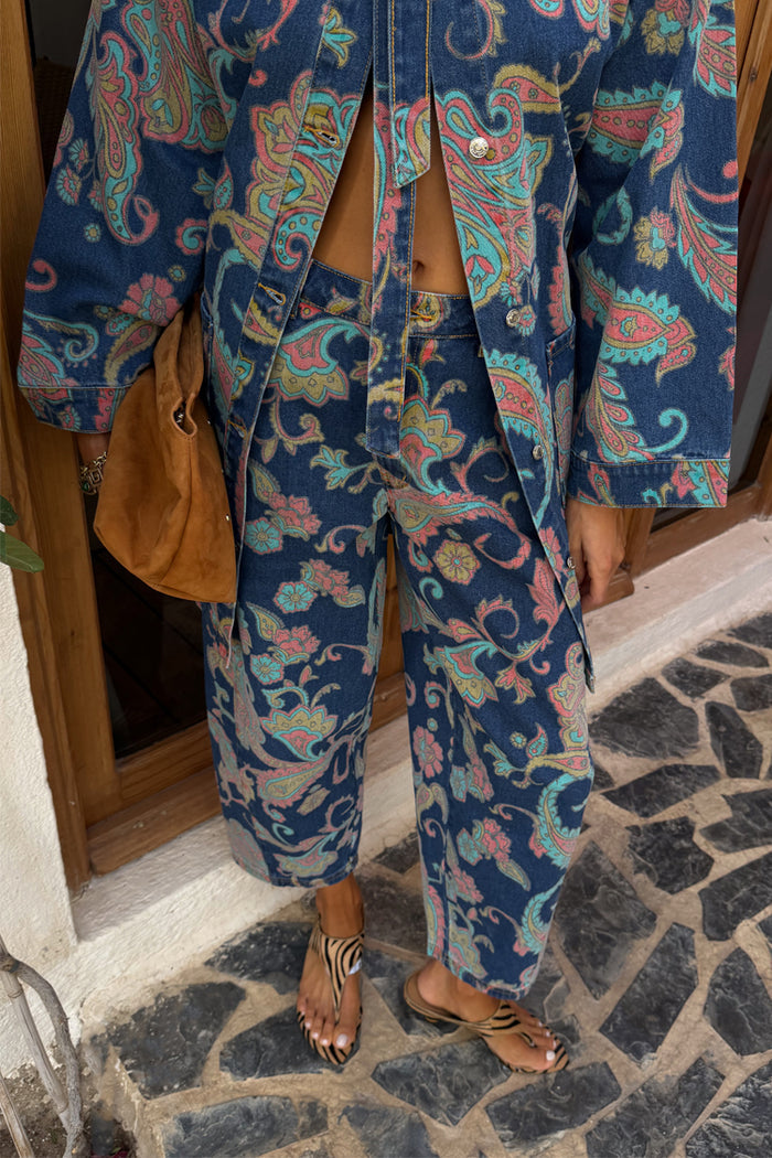 Denim Paisley Barrel Leg Jeans in blue with pink and teal patterns, styled with a matching shacket and brown suede bag.