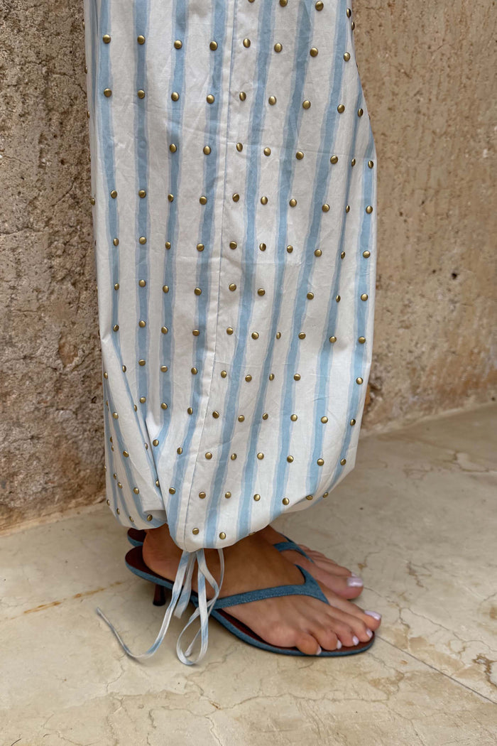Denim Sandal Mule featuring a low kitten heel and slim thong straps, styled with blue and white striped trousers.