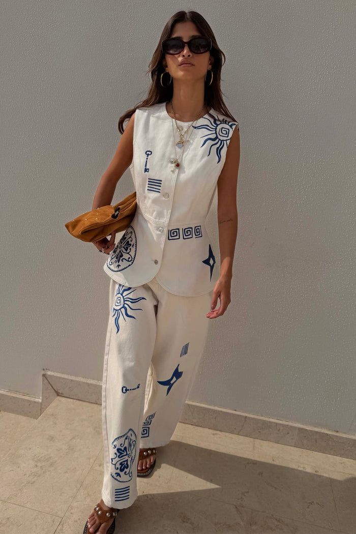 Dolce Vita ecru denim waistcoat featuring blue sun embroidery, styled with matching co-ord barrel leg jeans.