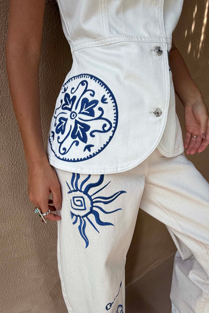 Dolce Vita Denim Waistcoat in ecru with blue sun embroidery and engraved buttons, styled with matching denim jeans.