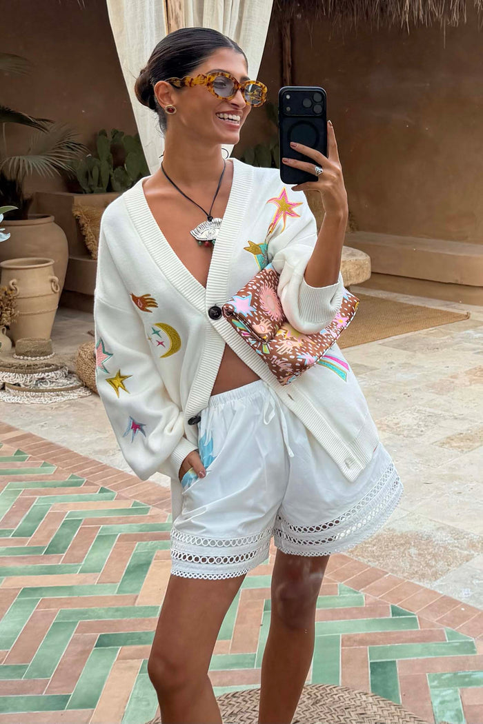 White Dreamer Ellie Shorts with cut-out hem detailing, styled with an iconic embroidered motif cardigan.