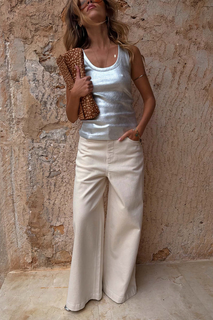 Ecru Jan Jeans with a wide palazzo leg, styled with a silver metallic top and leopard print clutch bag.