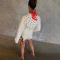 Ecru Studded Cardigan in cream with silver studs on the back and sleeves, styled with a red bandana and matching shorts.