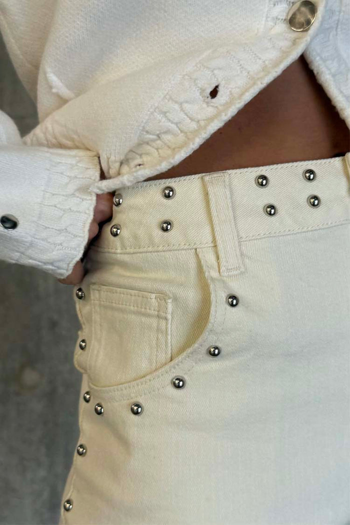 Ecru Studded Hot Pants in cream denim featuring silver stud detailing on the waistband and front pocket.