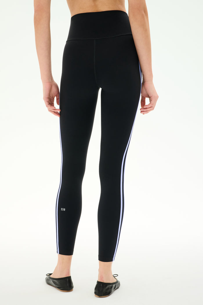Person wearing SPLITS59 Ella High Waist Airweight 7/8 leggings in Black/Purple Haze, seen from the back, standing against a white background.