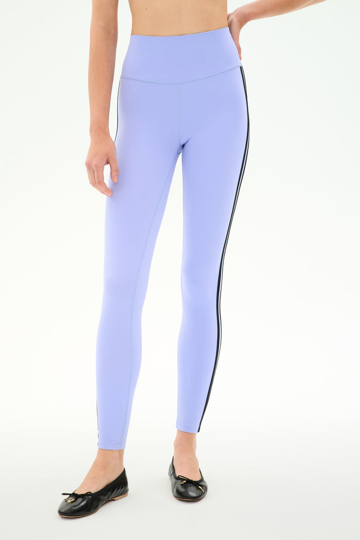 Model wears SPLITS59 Ella High Waist Airweight 7/8 leggings in Purple Haze/Black with black ballet flats, standing against a plain white background.