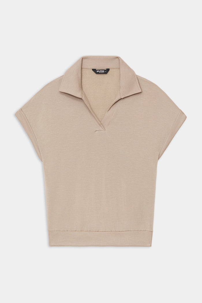 The SPLITS59 Evie Fleece Sleeveless Polo in Latte features a soft fleece fabric, sleeveless design, classic collar, and V-neckline, shown against a white background.