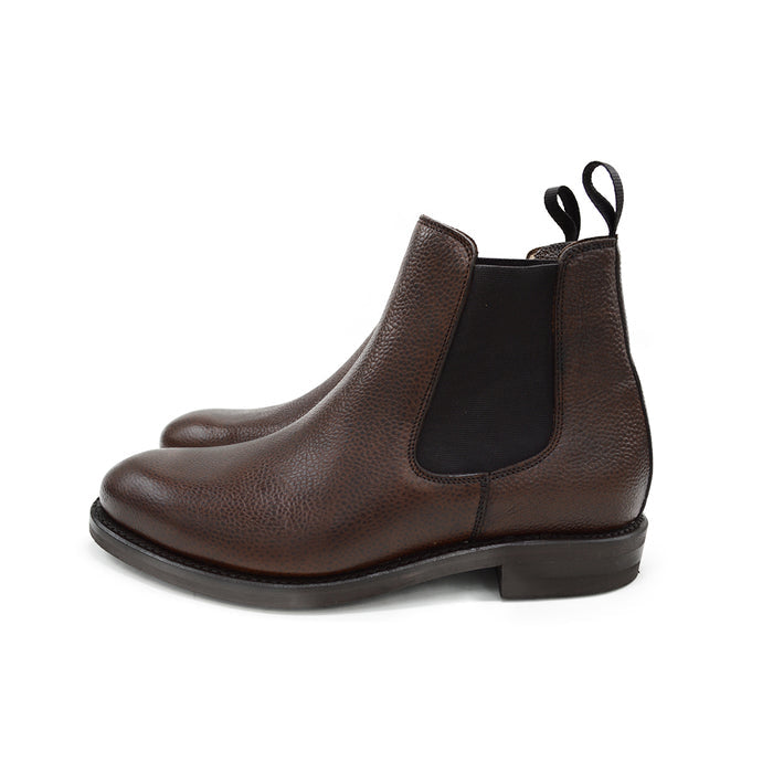 A dark brown grain leather Chelsea boot with a black elastic side panel and a round toe. The boot has a low heel and a goodyear welted dainite rubber sole.