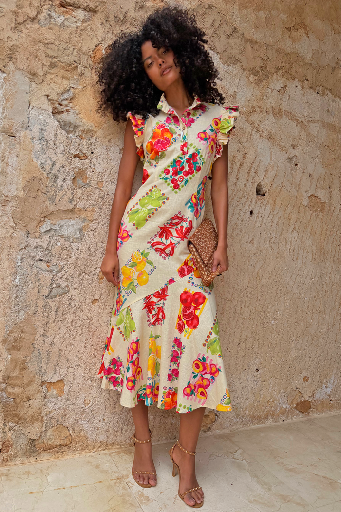 Fruit Stamps Remi Dress in white cotton linen featuring a fruit sticker print, ruffle sleeves and asymmetric hem.