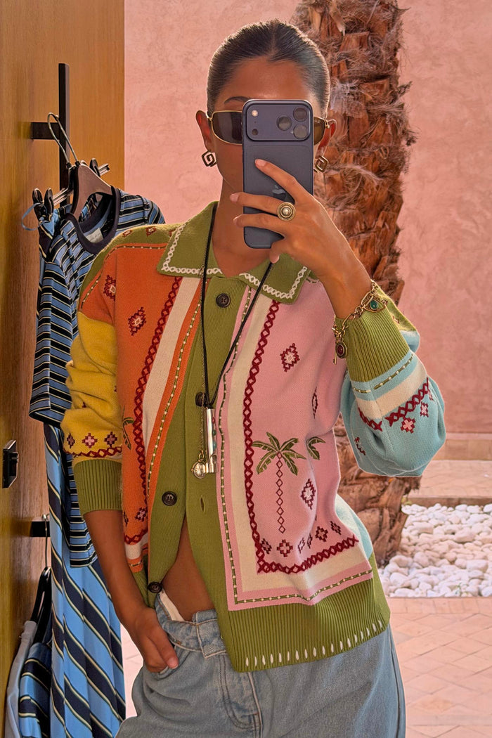 Geometric Palm Cardigan in green with multi-coloured jacquard motifs and blanket stitch detailing in a mirror selfie.