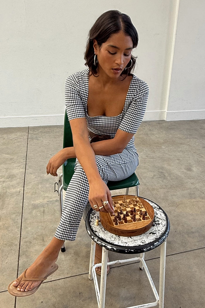 Gingham Top with a deep square neckline in a black and white check, styled as a co-ord while playing chess.