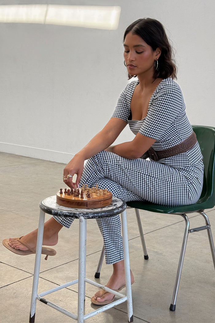 Gingham Trousers and matching top co-ord set in black and white check, worn by a model playing chess.