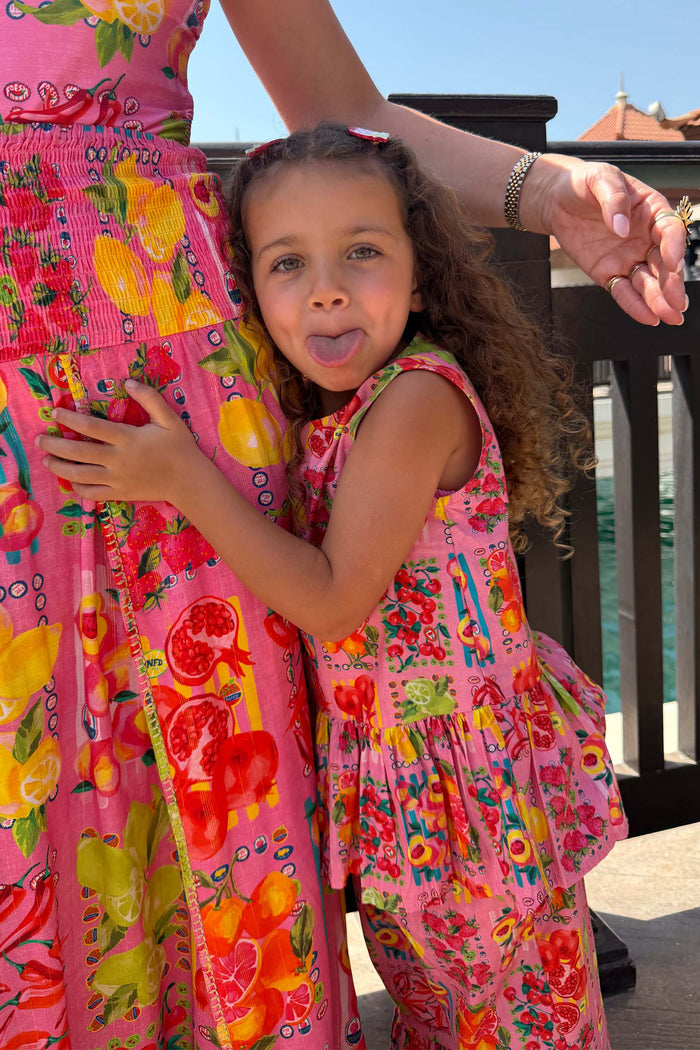 NFD Kids Pink Fruit Wide Leg Set with a peplum top, hugging a family member in a matching Mediterranean print.