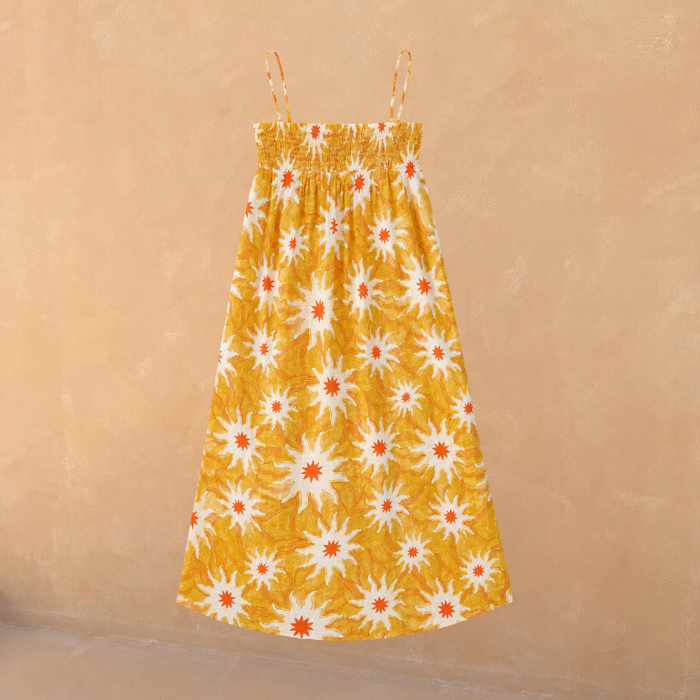 Girl's yellow cotton maxi sun dress with an orange sun print, shirred bodice and thin straps.