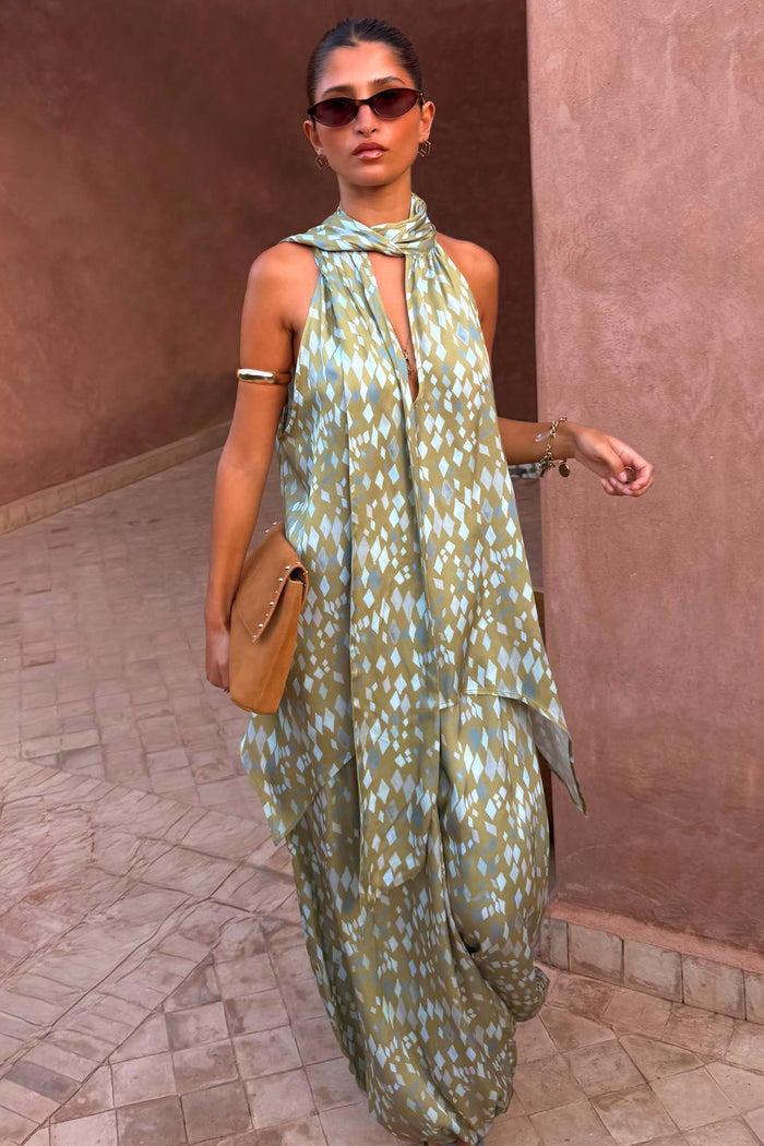 Green Diamond Print Halter Top in olive satin with a draped scarf and asymmetric hem, styled with matching trousers.