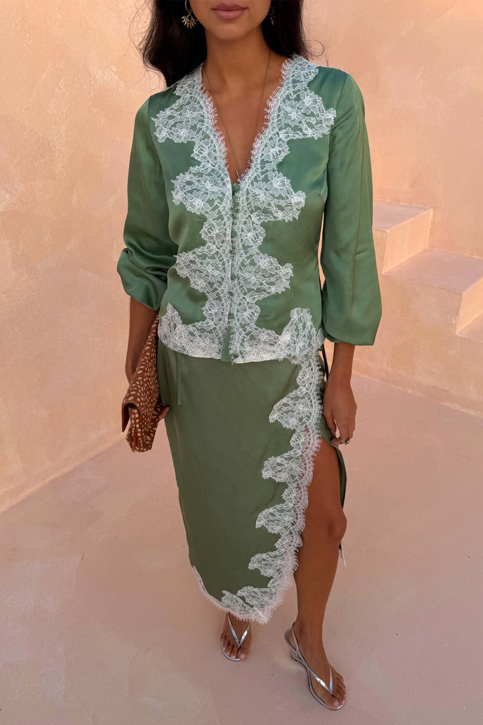 Green Lace Wrap Midi Skirt with white cascading lace detailing and a side slit, styled with a matching top.