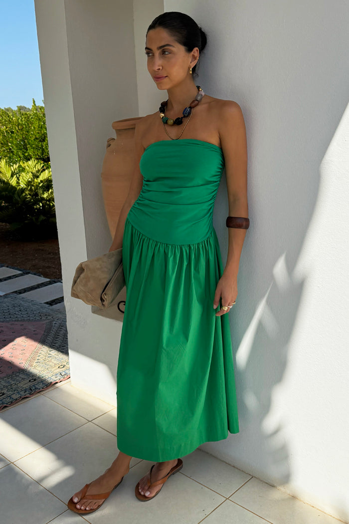 Green Lola Mid-axi Dress with a ruched strapless bodice and flowing cotton skirt, styled for a summer vacation.
