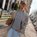Grey Rest and Recharge Jumper with red lettering, layered with a checked blazer and lace-trim denim for a London look.