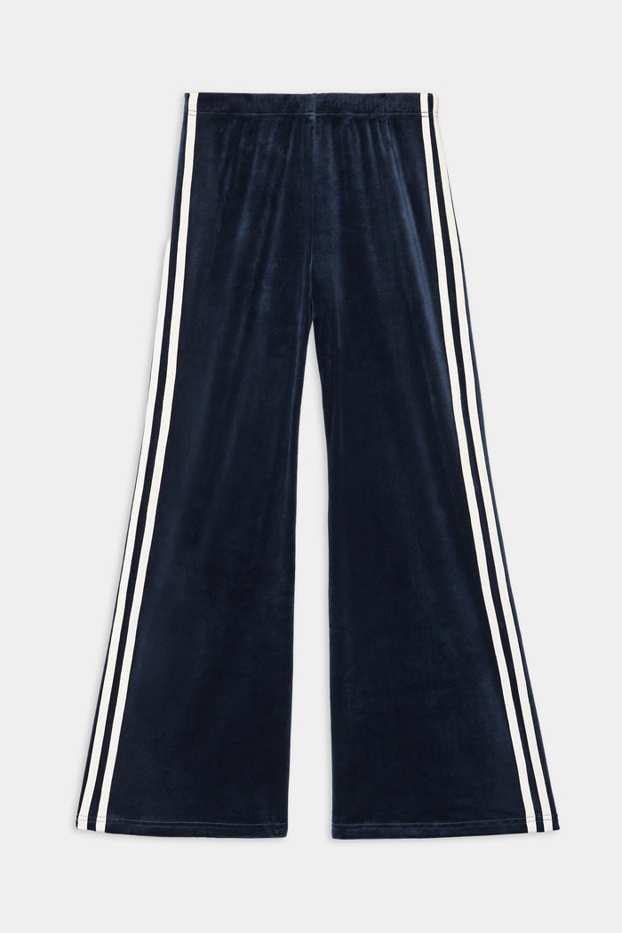 The SPLITS59 Heritage Velour Pant in Indigo/White features wide-leg styling, soft polyester-spandex fabric, and distinctive white double side stripes along the outer seams.