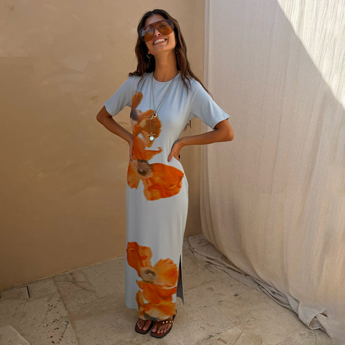 Ice Blue Floral Rib Dress with a bold orange floral print, short sleeves and a side slit on a model.