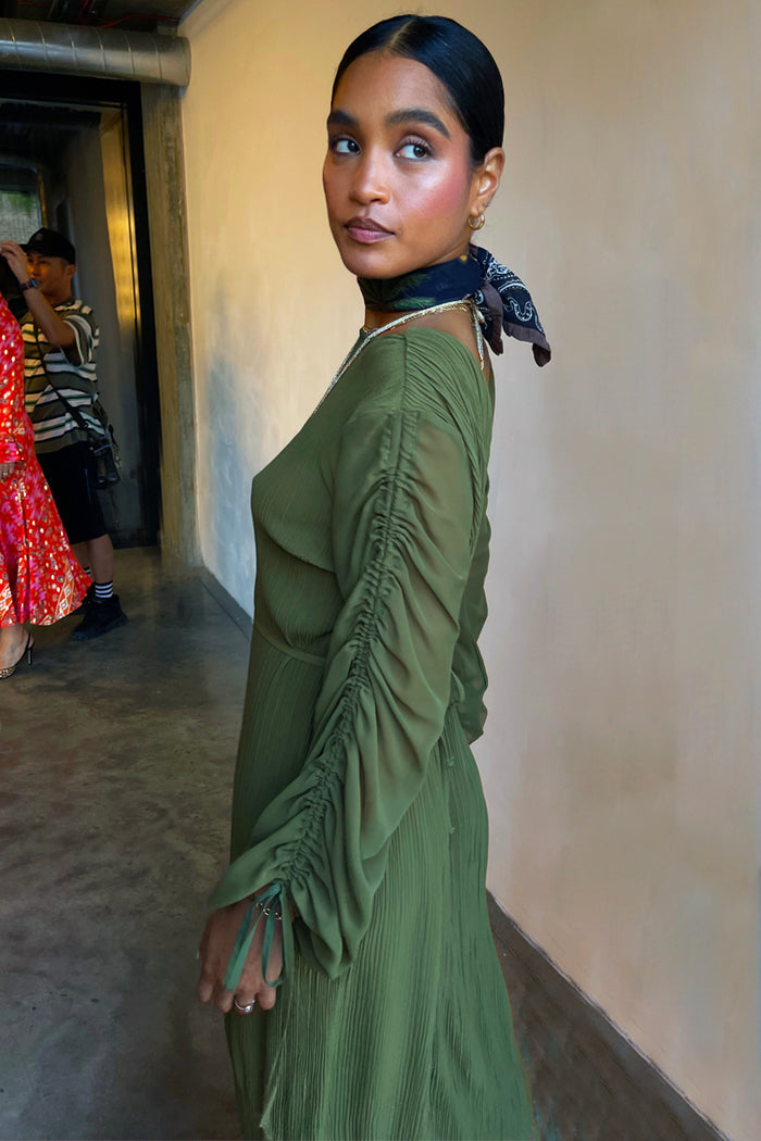 Khaki Celia Plisse Dress with long sheer ruched sleeves and tie details on a model.