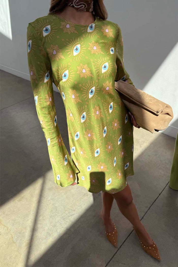 Khaki Eye Mini Soho Dress Petite featuring an iconic eye print and flared sleeves, styled with a tan clutch.