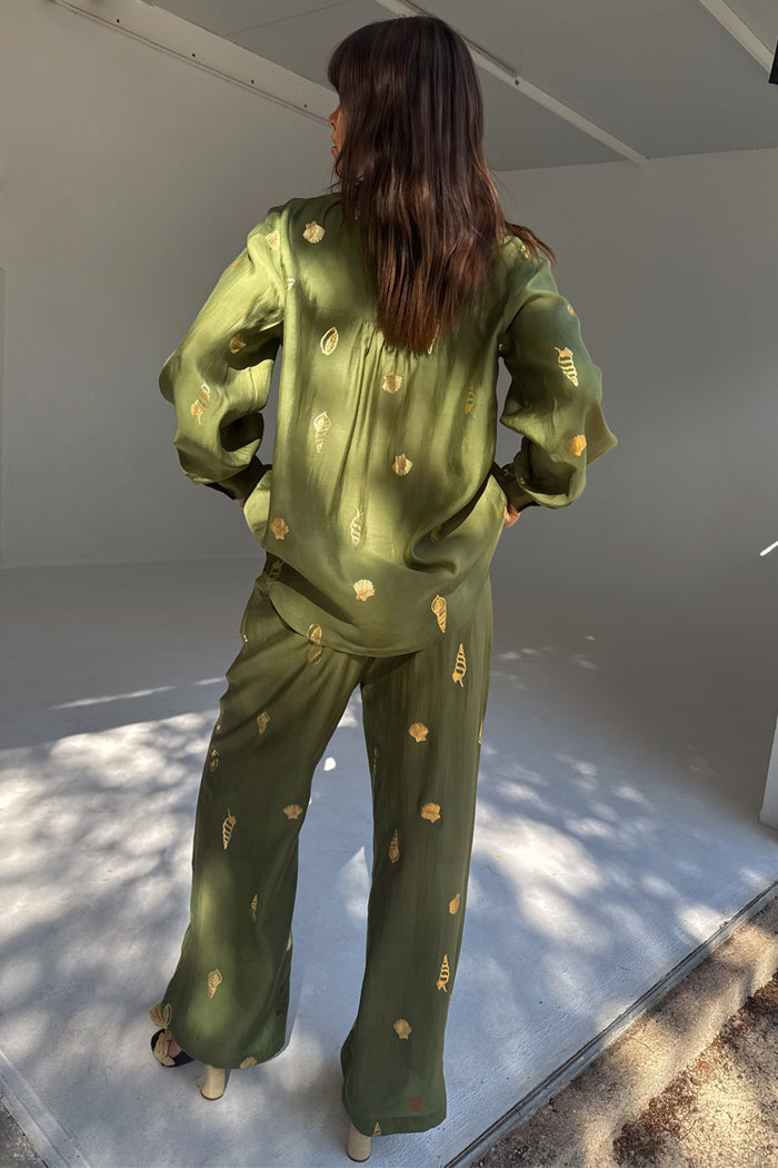 Khaki green wide-leg trousers with a gold shell print, styled as a co-ord with a matching shirt.