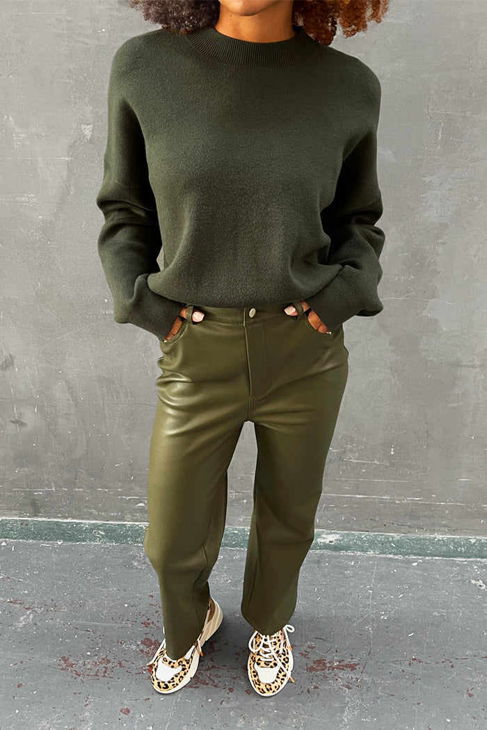 Khaki Vegan Leather Trousers with a dark green jumper and leopard print trainers.