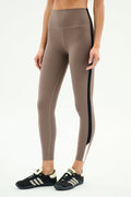 Model wears SPLITS59 Layla Airweight High Waist 7/8 leggings in Lentil/Black, showcasing ultra-soft fabric and black side stripe with black athletic shoes—ideal for hot yoga or daily wear, set against a plain white background.