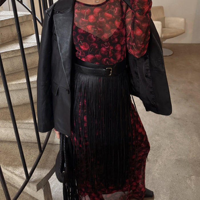 Black Leather Fringe Belt with a wide buckled band and long tassels, layered over a red cherry print dress.